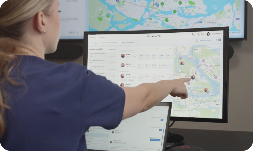 Healthcare professional pointing at a digital dashboard showing patient planning and a live map for visit coordination